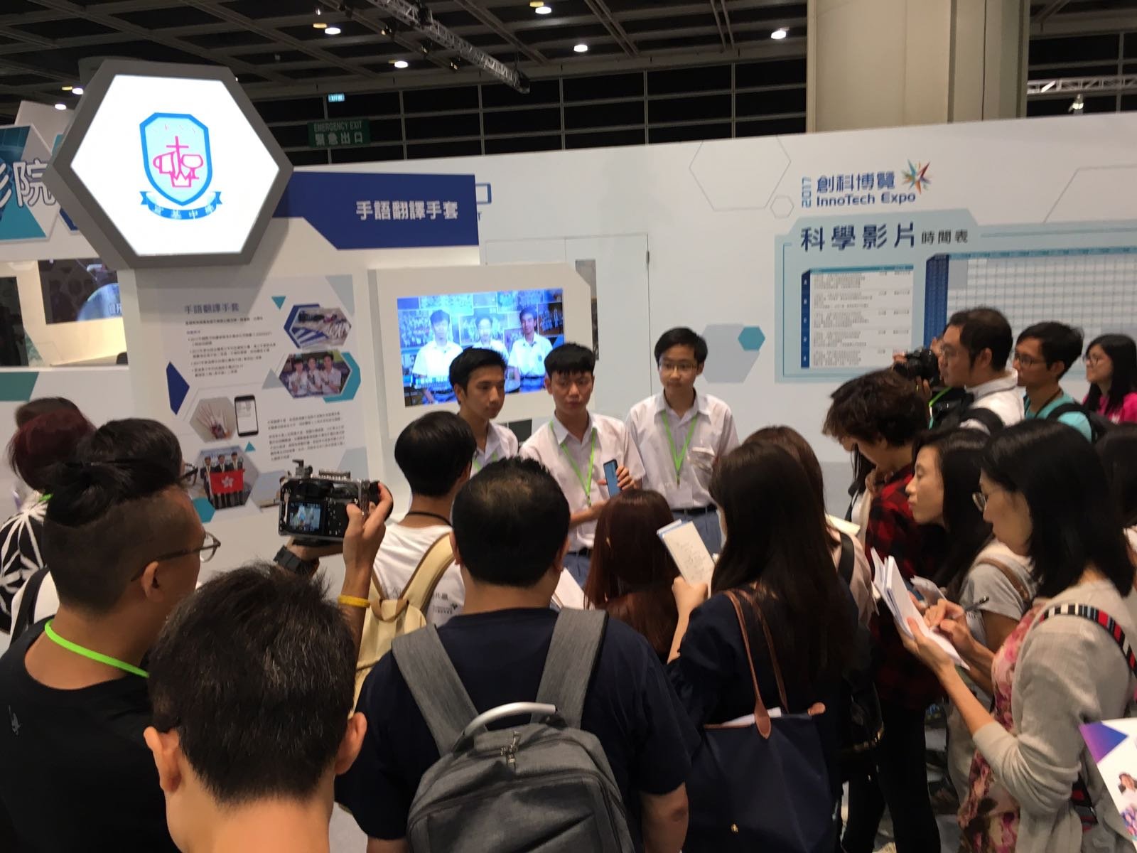 Press and camera crews around the gloves exhibit at InnoTech Expo